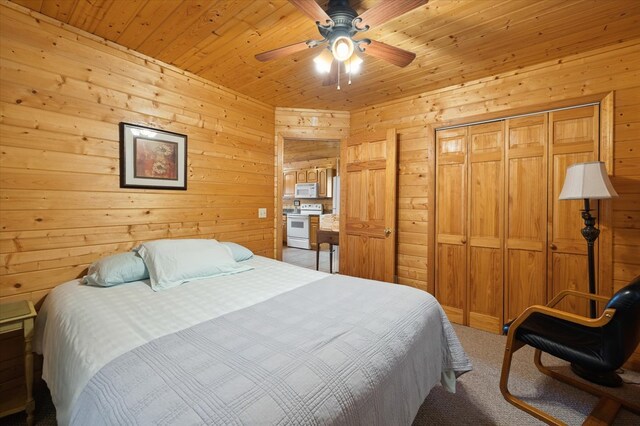 bedroom with carpet floors, wood ceiling, a closet, and wooden walls