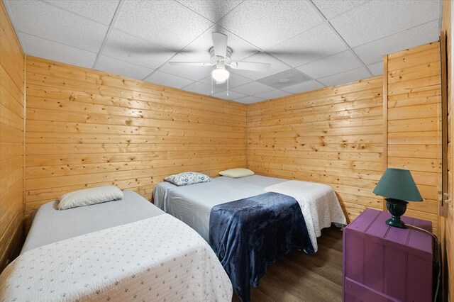 bedroom featuring dark wood-style floors and wooden walls