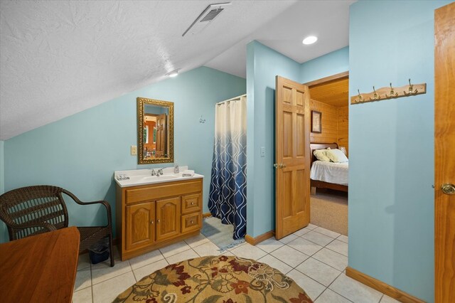 full bathroom with lofted ceiling, a textured ceiling, connected bathroom, vanity, and visible vents