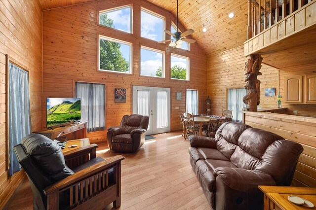 living room featuring french doors, light wood-style floors, a ceiling fan, high vaulted ceiling, and wooden ceiling