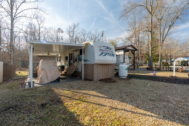 view of outdoor structure with an attached carport and fence