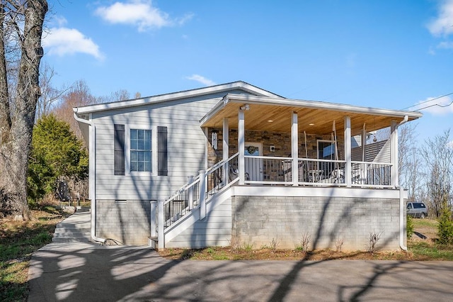 view of front of home featuring covered porch and stairs