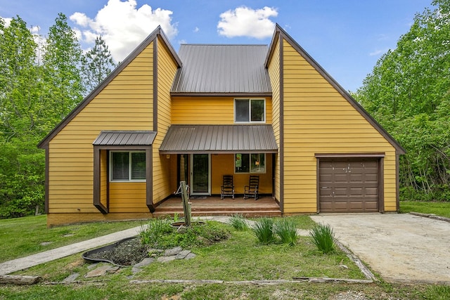 view of front of house featuring a garage, metal roof, a porch, and driveway