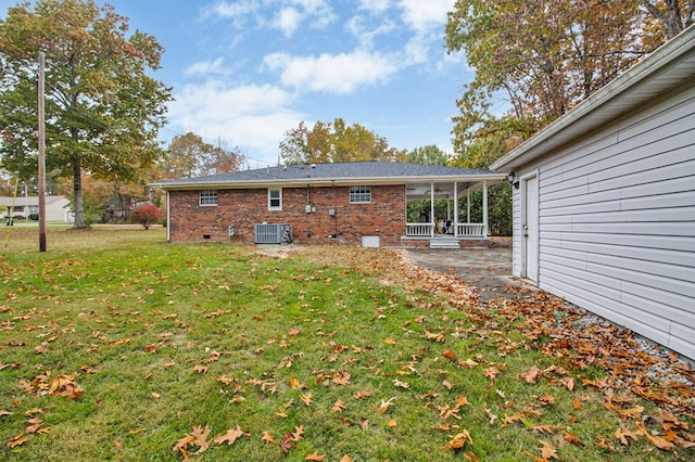 back of property with crawl space, brick siding, cooling unit, and a yard