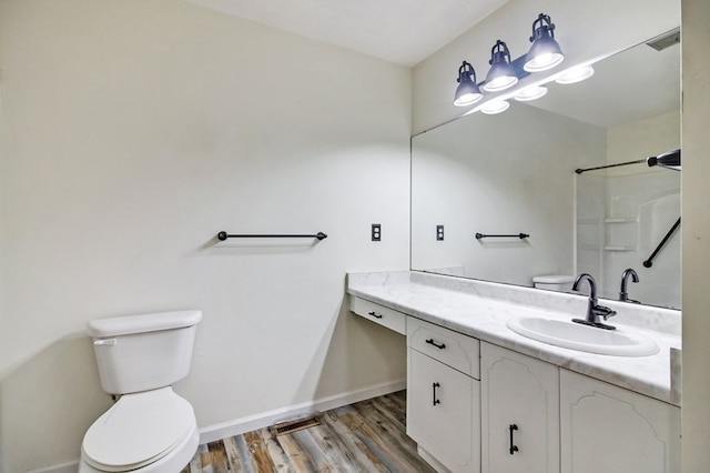 full bath featuring a shower, toilet, vanity, wood finished floors, and baseboards