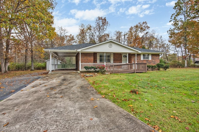 view of front of home featuring driveway, brick siding, an attached carport, and a front yard