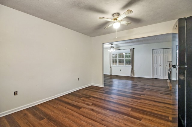 unfurnished room with dark wood-style floors, ceiling fan, baseboards, and a textured ceiling