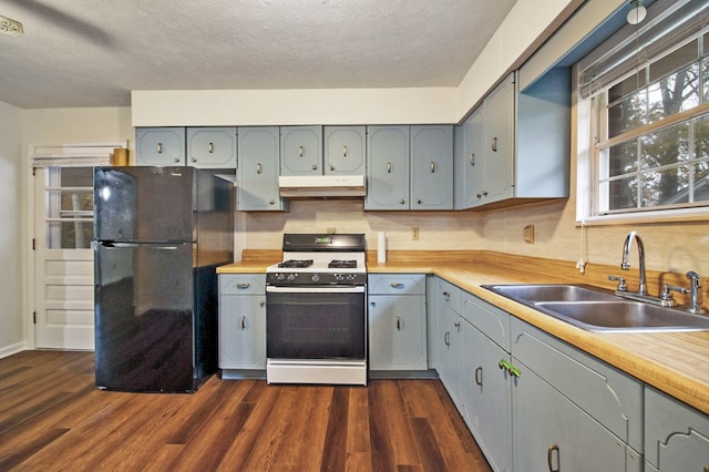 kitchen with range with gas stovetop, freestanding refrigerator, and light countertops