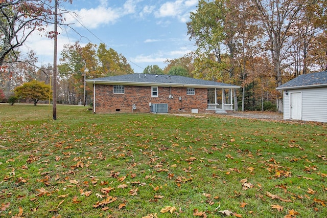 rear view of property with crawl space, brick siding, a yard, and central AC unit