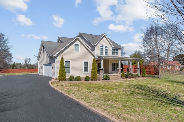 view of front of property with a front yard, fence, driveway, a porch, and an attached garage