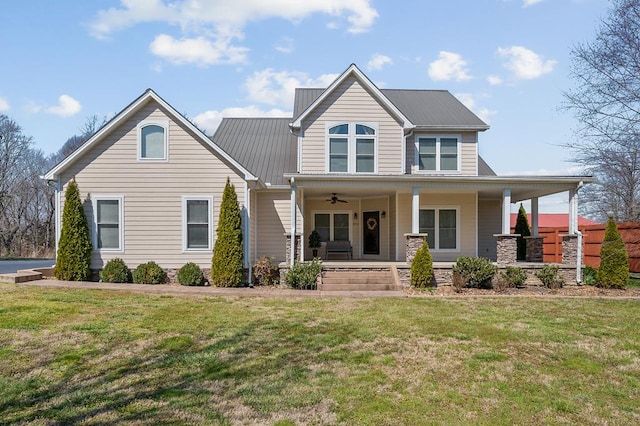 view of front of home with a porch, a front yard, and metal roof