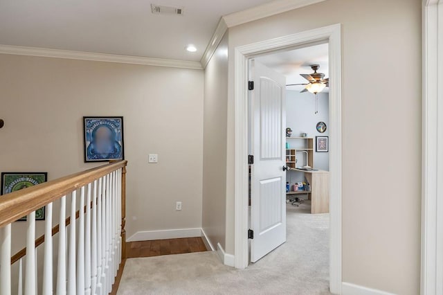 hallway featuring visible vents, carpet, baseboards, and ornamental molding