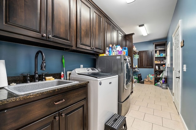 clothes washing area featuring light tile patterned flooring, cabinet space, independent washer and dryer, and a sink