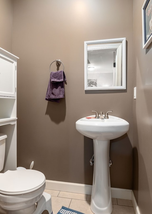 bathroom with tile patterned floors, baseboards, and toilet