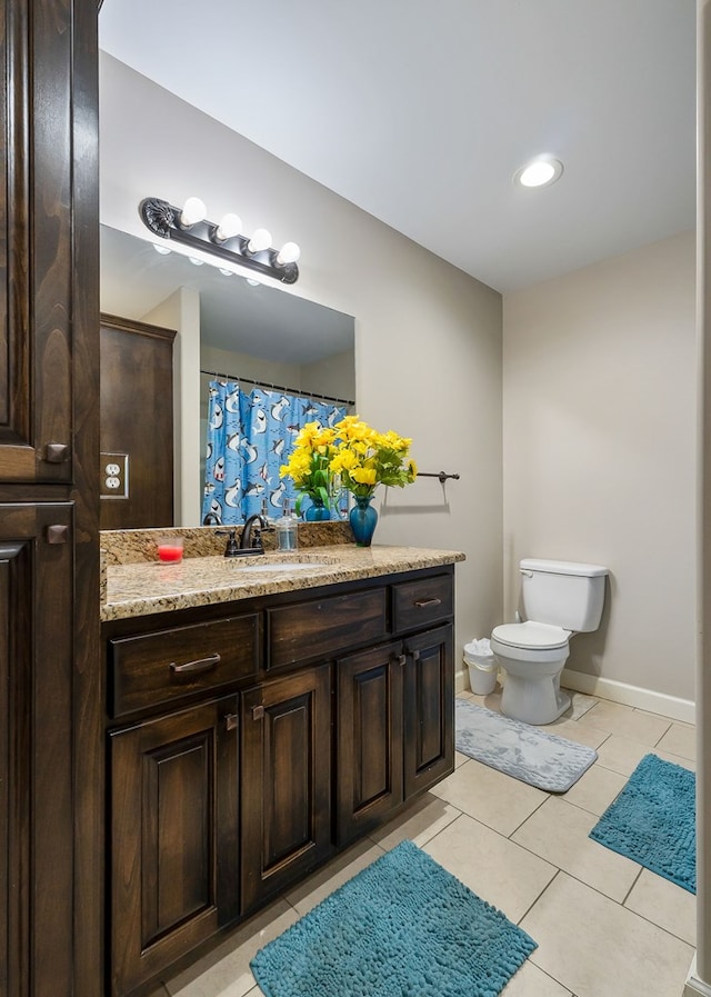 bathroom featuring vanity, tile patterned floors, toilet, and baseboards