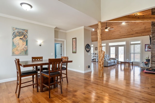 dining room with crown molding, a ceiling fan, baseboards, and wood-type flooring