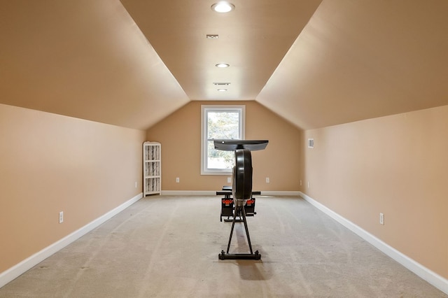 workout area featuring visible vents, baseboards, lofted ceiling, and light carpet