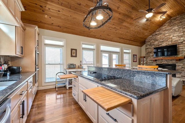 kitchen featuring a center island, stainless steel appliances, light wood-style floors, lofted ceiling, and wood ceiling