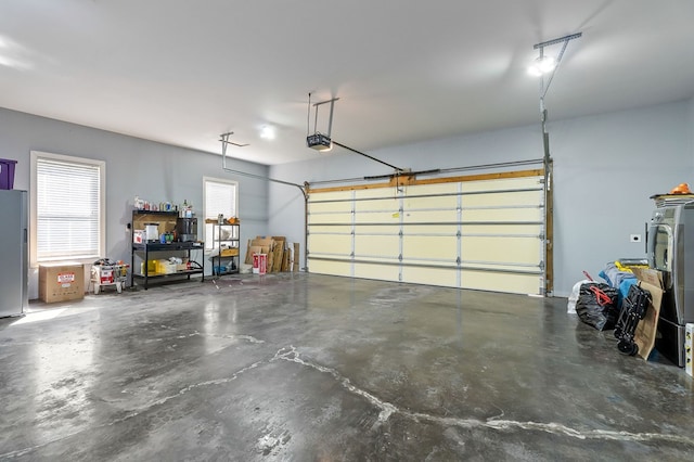 garage with a garage door opener and freestanding refrigerator