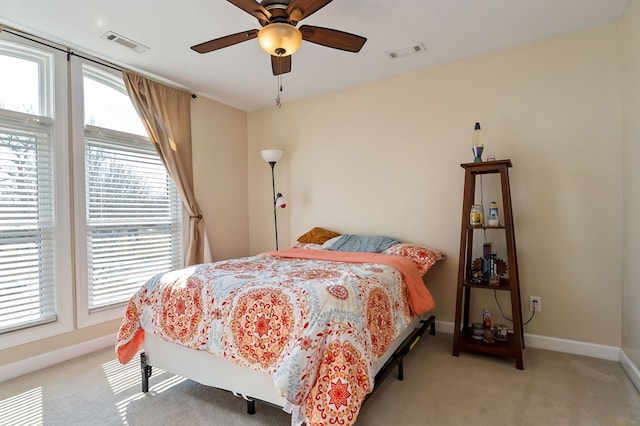 bedroom featuring light carpet, visible vents, a ceiling fan, and baseboards