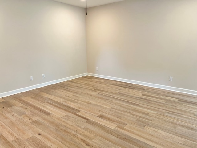 unfurnished room with light wood-style flooring and baseboards