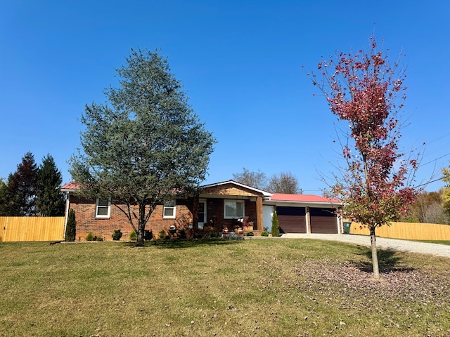 ranch-style home with a garage, brick siding, fence, and a front yard