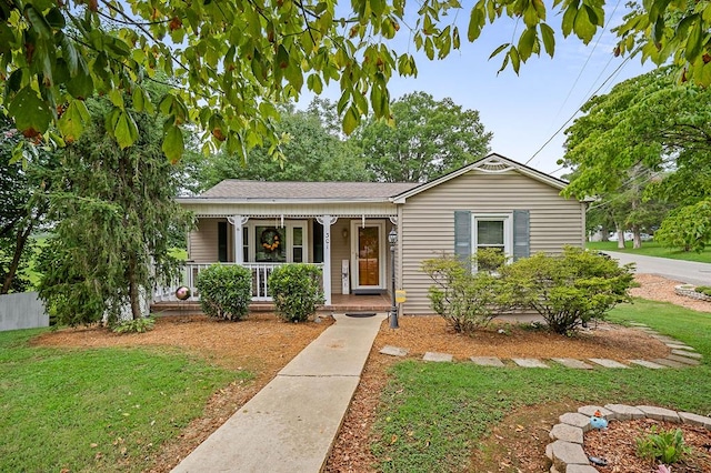 view of front of home featuring a porch, a front yard, and fence