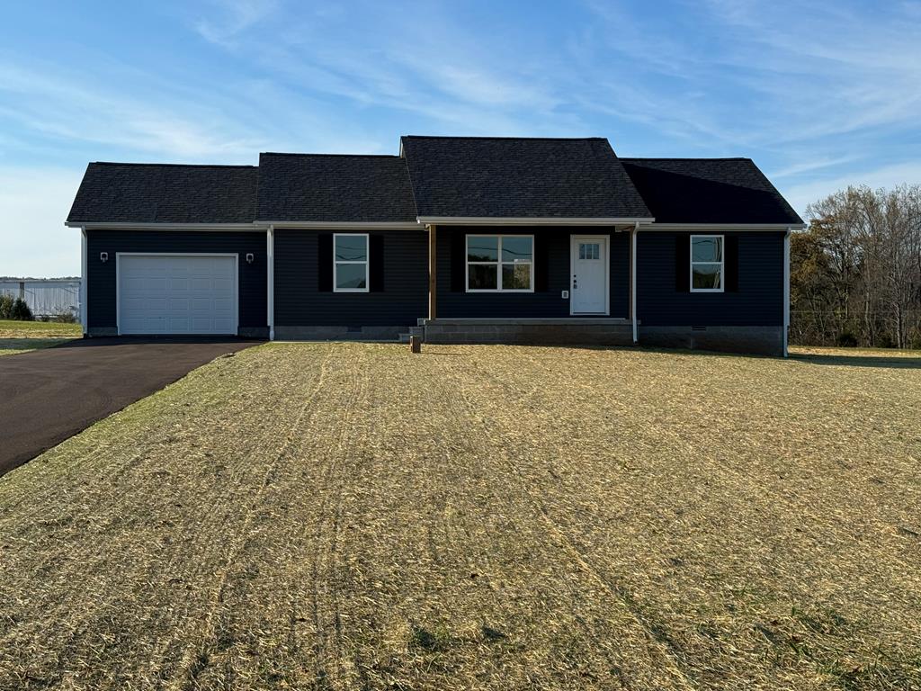 ranch-style house featuring a front lawn, crawl space, driveway, and an attached garage