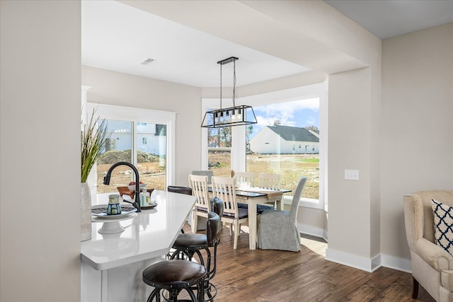 dining area featuring visible vents, baseboards, and dark wood finished floors