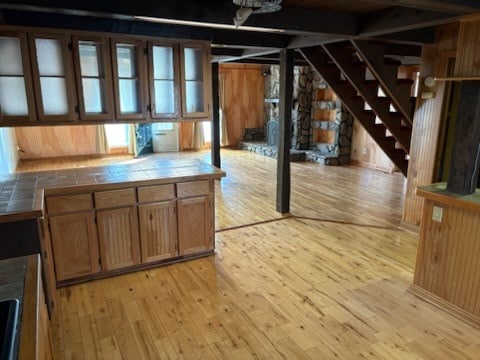 below grade area with wooden walls, stairway, and light wood-style floors