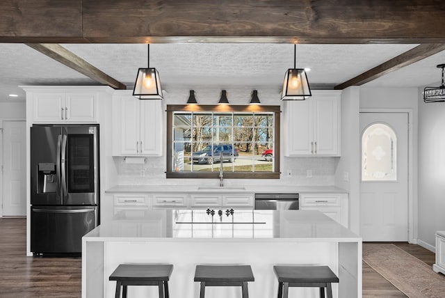 kitchen featuring appliances with stainless steel finishes, beamed ceiling, and a breakfast bar