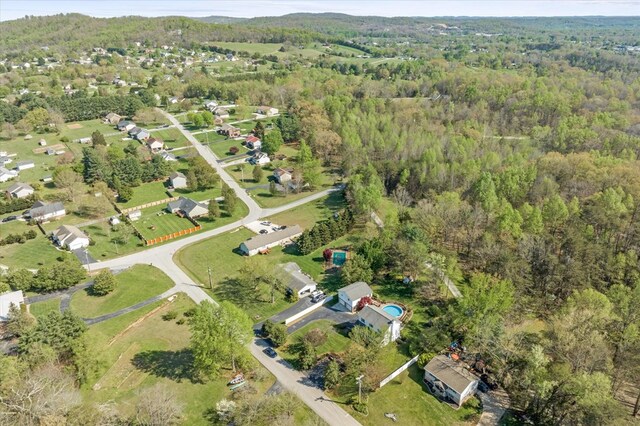 bird's eye view with a wooded view