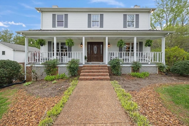 farmhouse inspired home featuring covered porch and a chimney