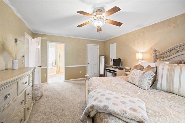 bedroom featuring connected bathroom, light carpet, a ceiling fan, baseboards, and ornamental molding