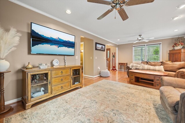 living area featuring light wood finished floors, baseboards, and crown molding