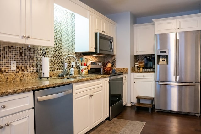 kitchen with a sink, decorative backsplash, dark wood-type flooring, appliances with stainless steel finishes, and white cabinetry