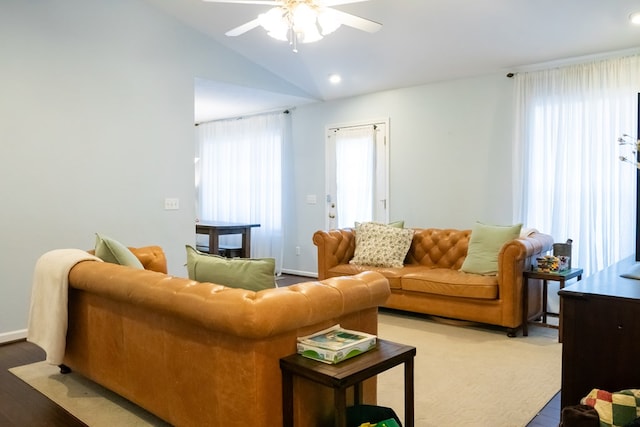 living area with a ceiling fan, vaulted ceiling, wood finished floors, and baseboards