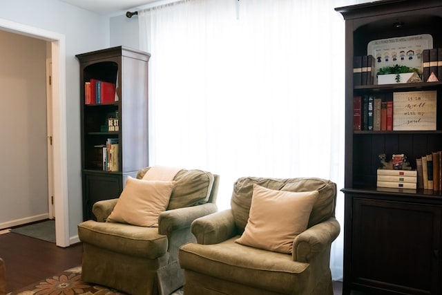 living area with baseboards and wood finished floors