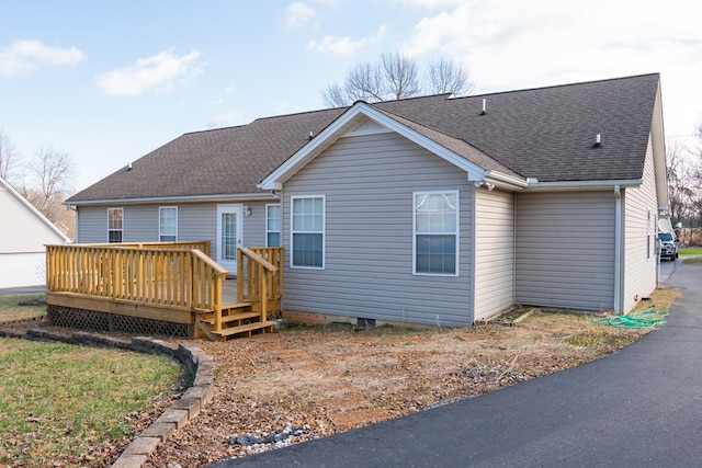 back of property featuring a wooden deck and a shingled roof