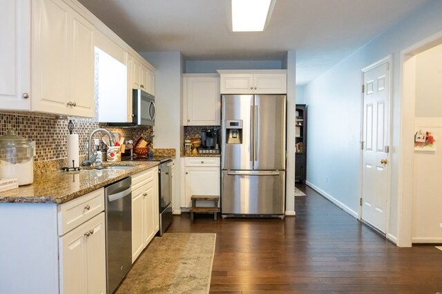 kitchen with dark wood-style floors, white cabinetry, stainless steel appliances, and a sink