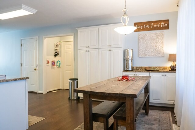 kitchen featuring white cabinetry, dark wood finished floors, stone counters, and pendant lighting