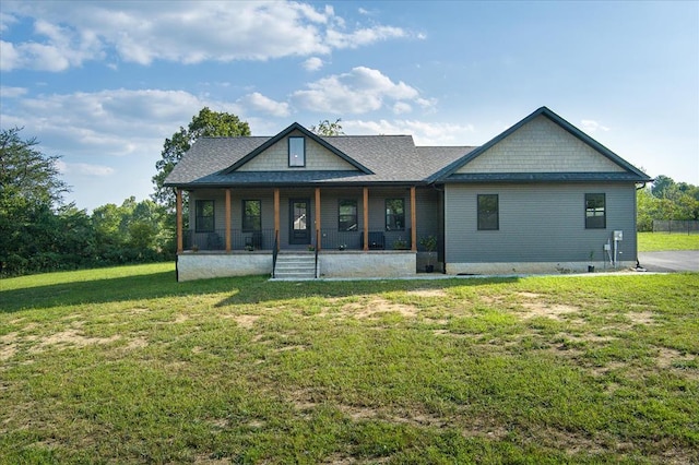 rear view of house featuring a porch and a lawn