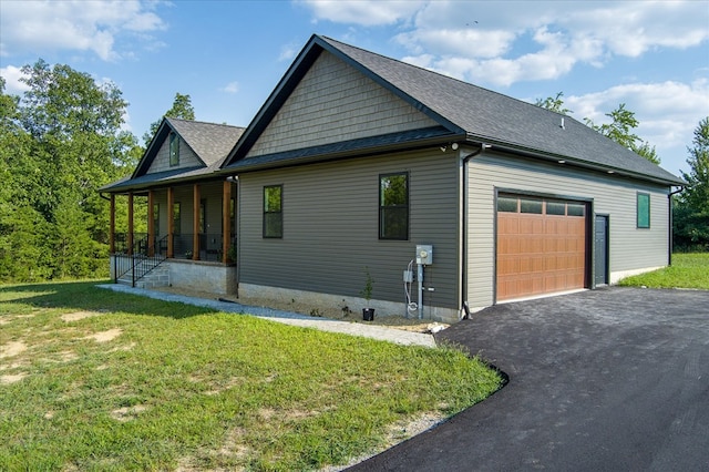 view of property exterior featuring driveway, a garage, a shingled roof, covered porch, and a yard