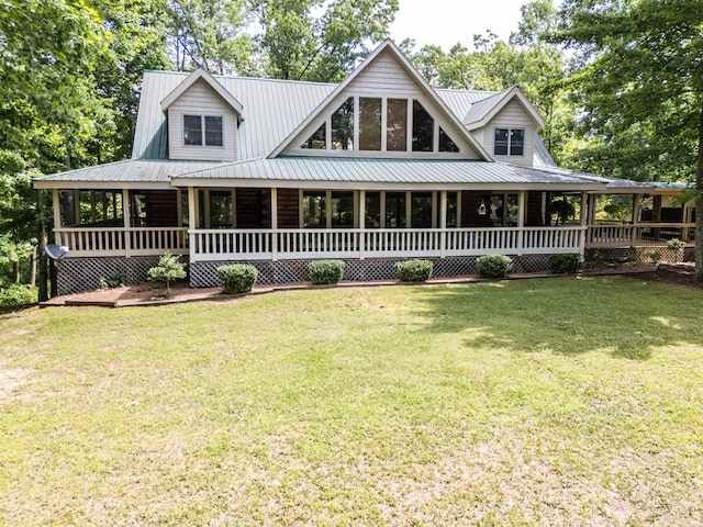 farmhouse featuring covered porch, metal roof, and a front yard