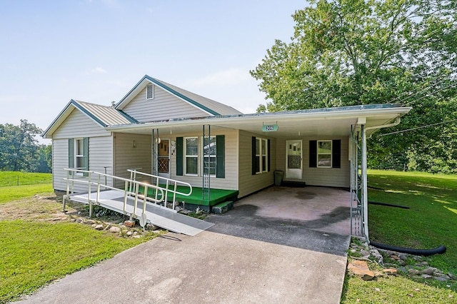 view of front of property featuring metal roof, driveway, a carport, and a front yard