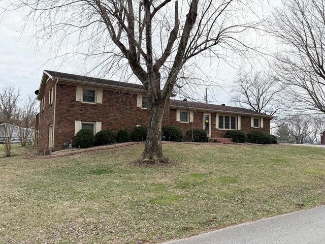 view of front of house featuring brick siding and a front lawn