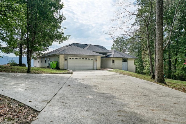 view of front of home featuring a garage, concrete driveway, and brick siding