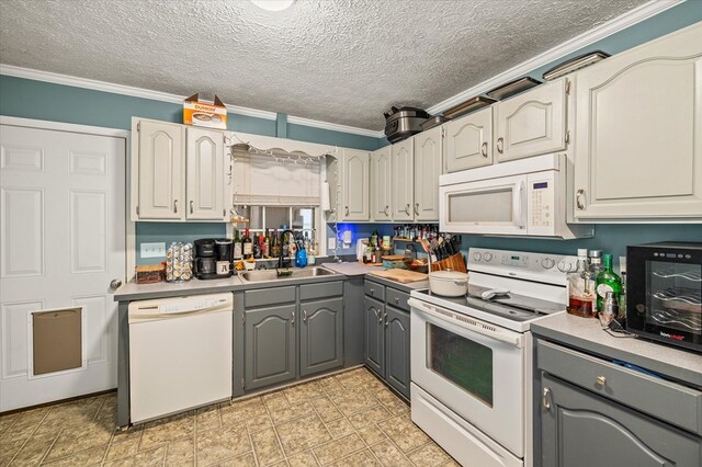 kitchen with gray cabinets, ornamental molding, white cabinets, a sink, and white appliances