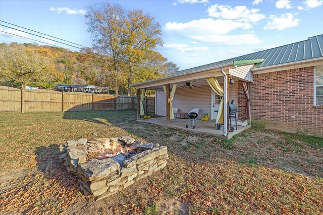 view of yard with a fenced backyard, a patio, a fire pit, and ceiling fan