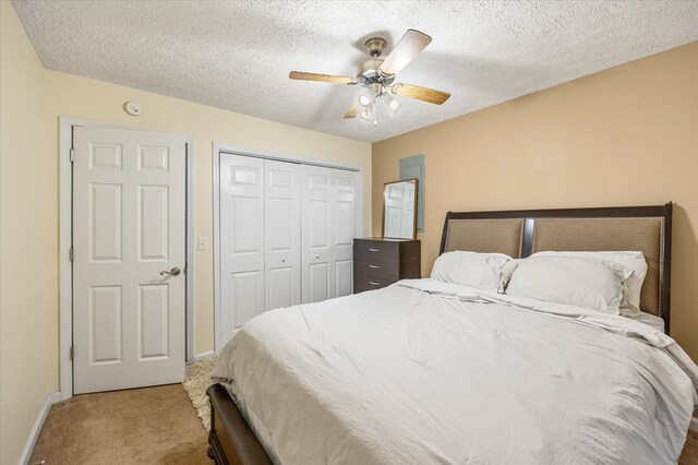 bedroom with carpet, a closet, a ceiling fan, a textured ceiling, and baseboards